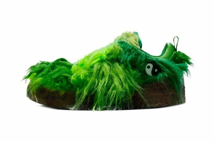 A weird green furry shoe with a yin-yang symbol on the side.
