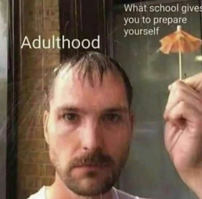 A man standing in the rain holding a small umbrella, symbolizing adulthood challenges and therapy humor.