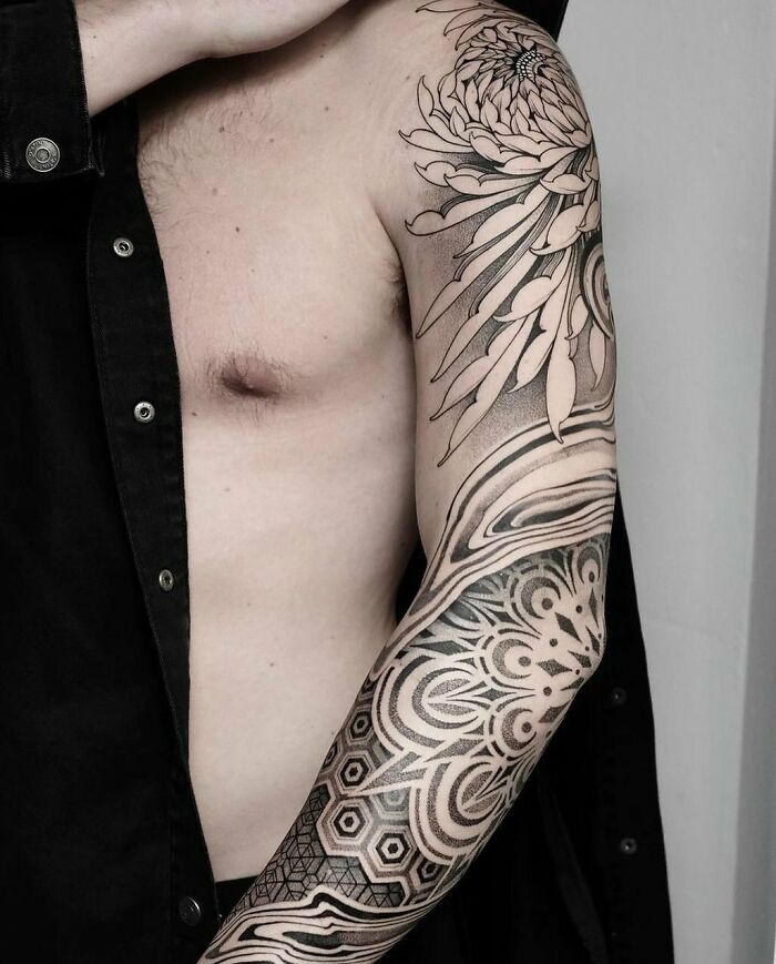 Geometric tattoos featuring intricate floral and hexagonal patterns on a person's arm.