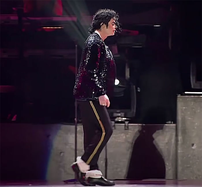 Michael Jackson doing a moon walk on stage 