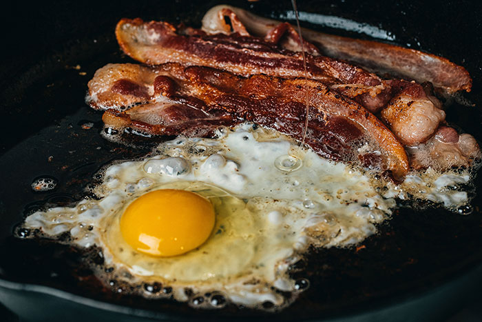 Bacon and egg frying in a pan 