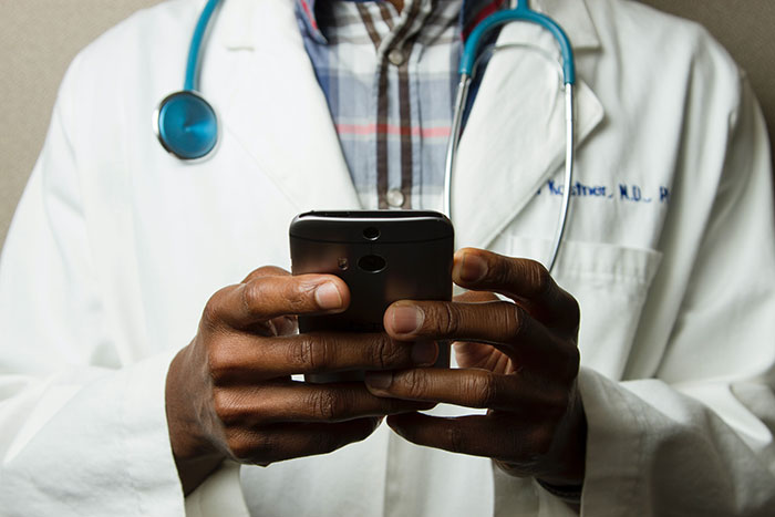 Doctor wearing his clothes and using a mobile phone 