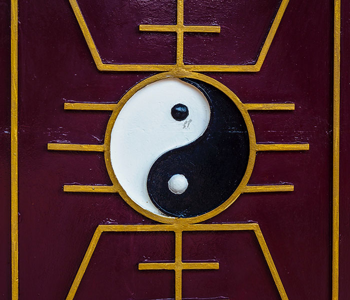 Yin And Yang on a purple and yellow wall 