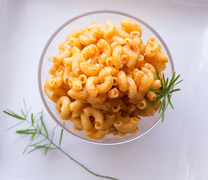 Mac and cheese with rosemary in a glass bowl 