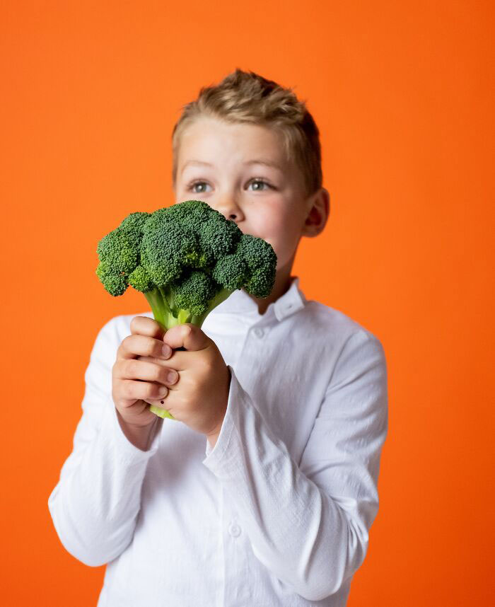 Boy Holding Broccoli In His Hands 