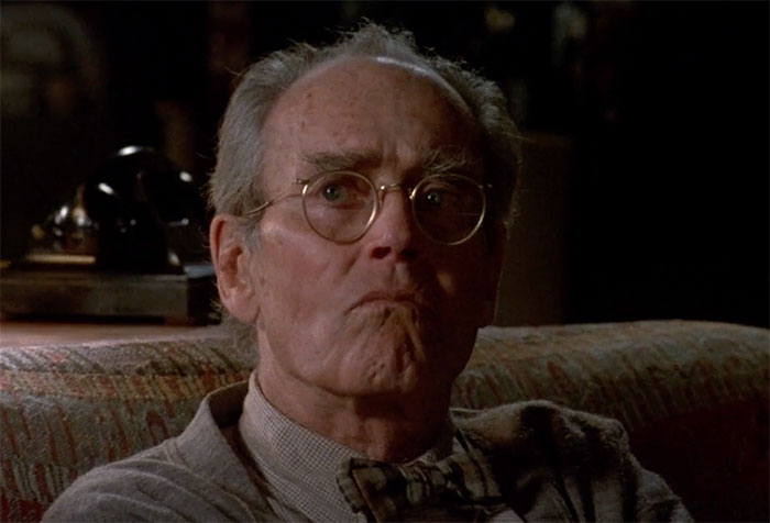Henry Fonda with glasses sitting and looking in movie On Golden Pond