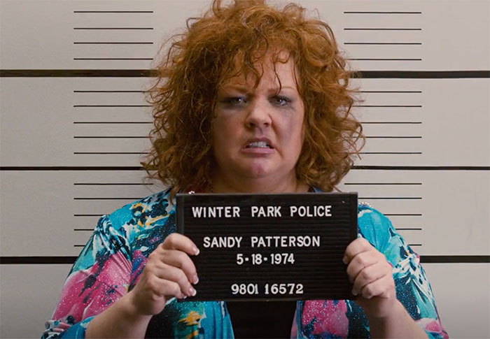 Melissa McCarthy holding sign in movie Identity Thief