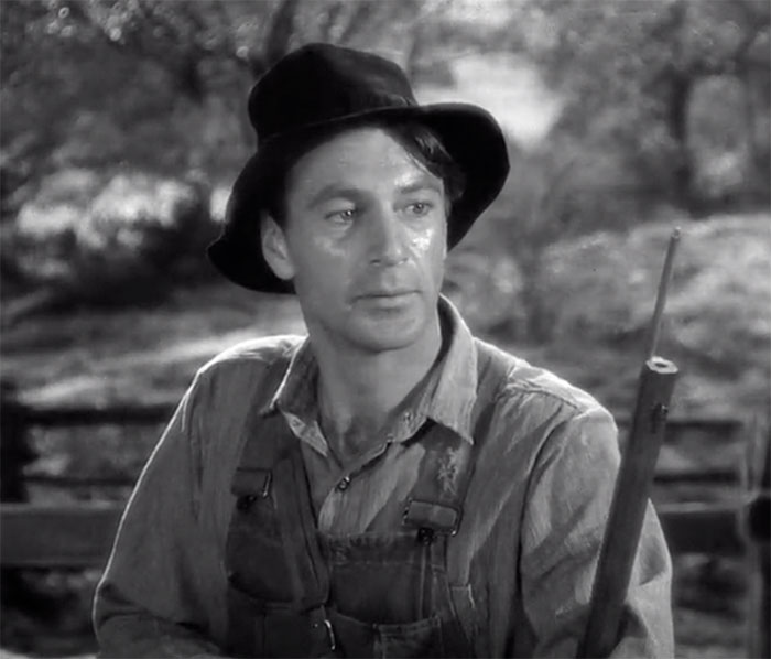 Gary Cooper standing and holding gun in movie Sergeant York