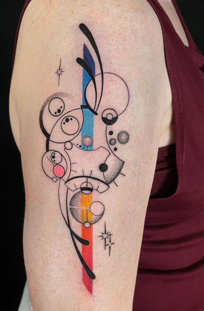 Abstract geometric black and color tattoo on arm