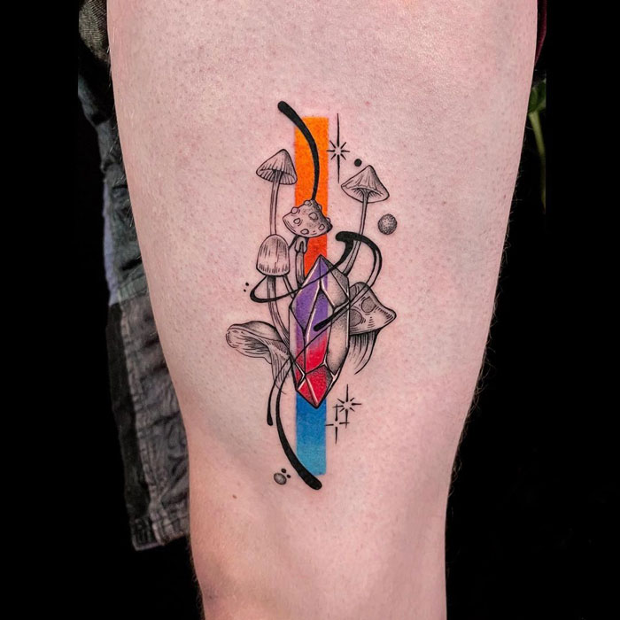 Geometric tattoo featuring mushrooms, abstract shapes, and colorful forms on leg, showcasing creativity in design.