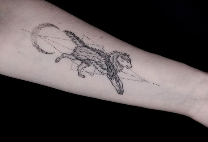Wolf and moon tattoo on arm