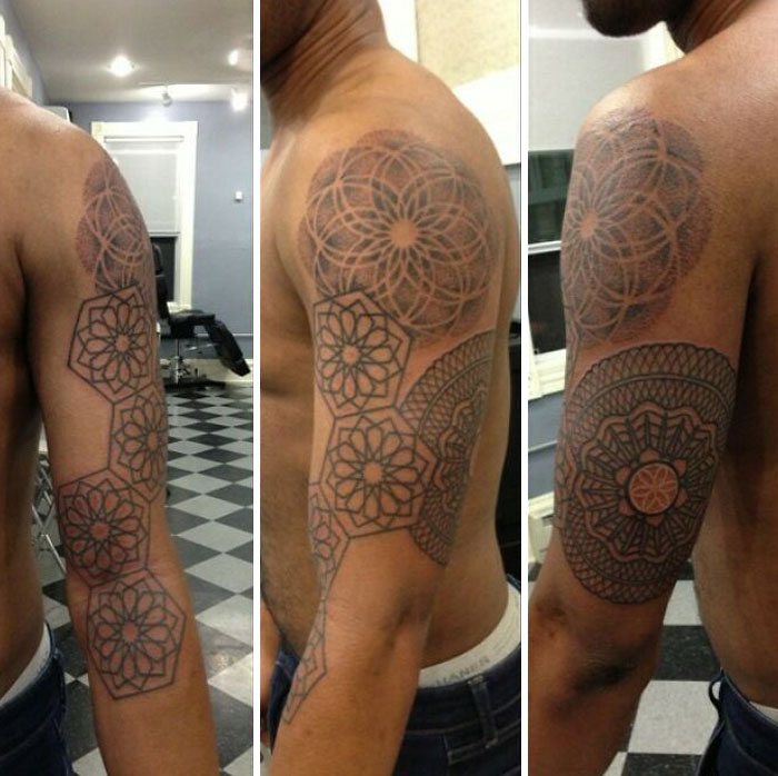 Geometric tattoos featuring intricate designs on a person's upper arm in a tattoo studio setting.
