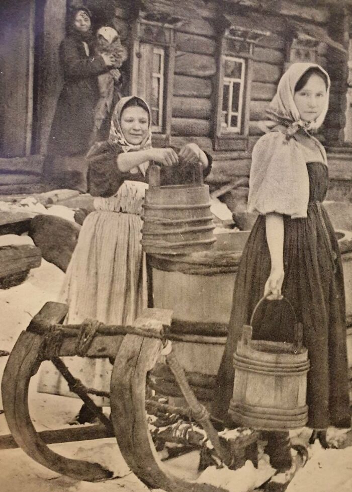 Campesinas que llevaban agua de un carro a una cabaña, imperio ruso (1910) 