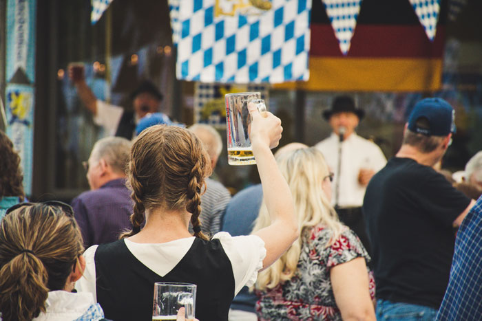 A girl holding a glass of beer in a crowd of people