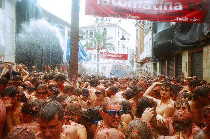 Crowd of people covered in tomatoes at La Tomatina festival in Spain