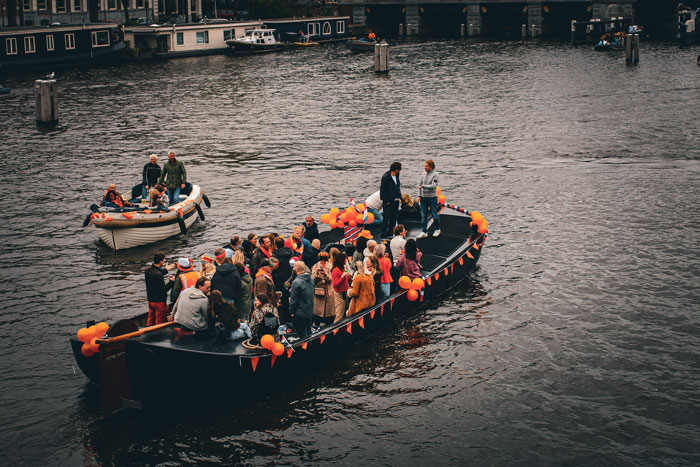 A group of people swimming in orange decorated boats