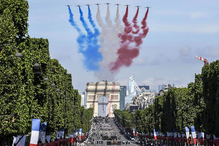 U.S. forces participate in the Bastille Day parade in Paris on July 14, 2017, while French Alpha jets fly overhead in a flyover
