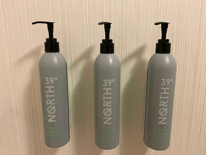 Nearly Invisible Label Text On The Hotel Shower Dispenser Bottles. Which One Is Shampoo? Good Luck If You're Not Wearing Your Glasses