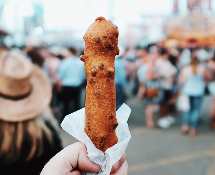Person holding corn dog