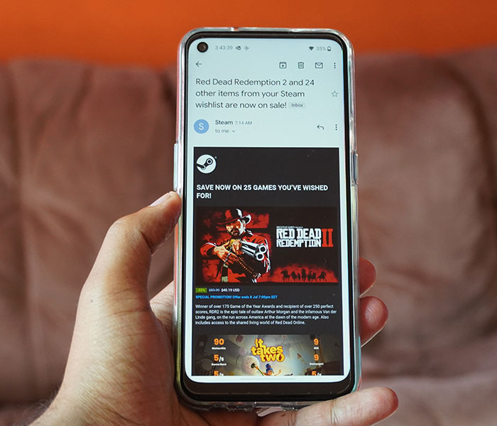 Person holding phone and looking for Steam games