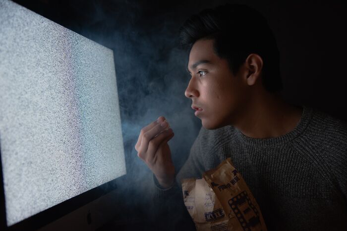 Person looking TV and eating popcorn
