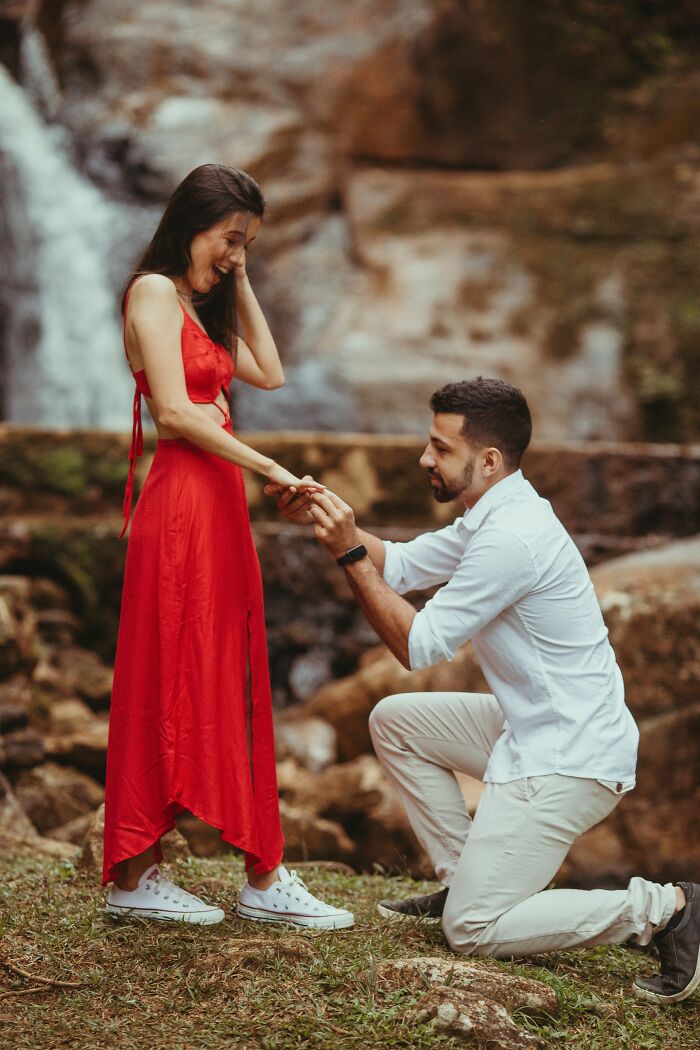 Man Proposing To His Girlfriend Near The Waterfall 