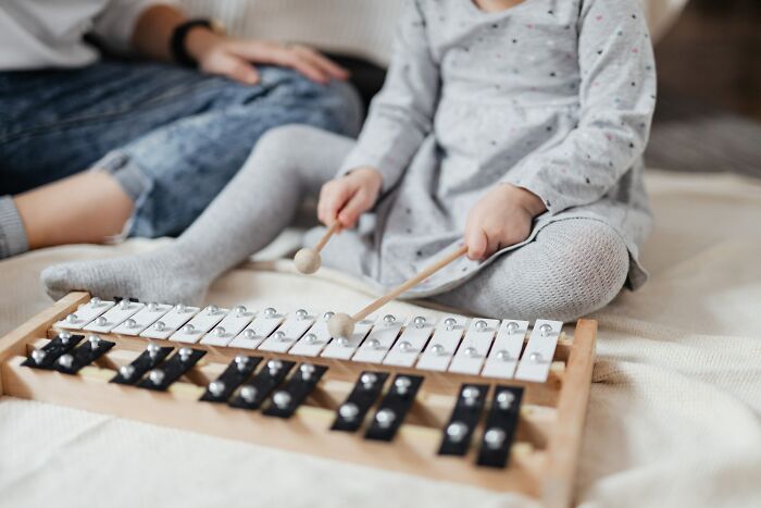 Baby Playing On Xylophone With Wooden Sticks 