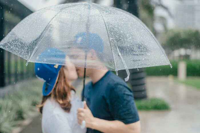 Couple Kissing Under An Umbrella 