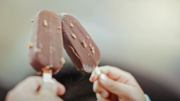 Two People Eating Ice Cream On A Stick 