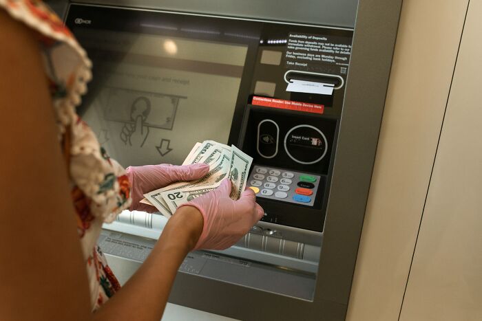 Woman Counting Money At The ATM 