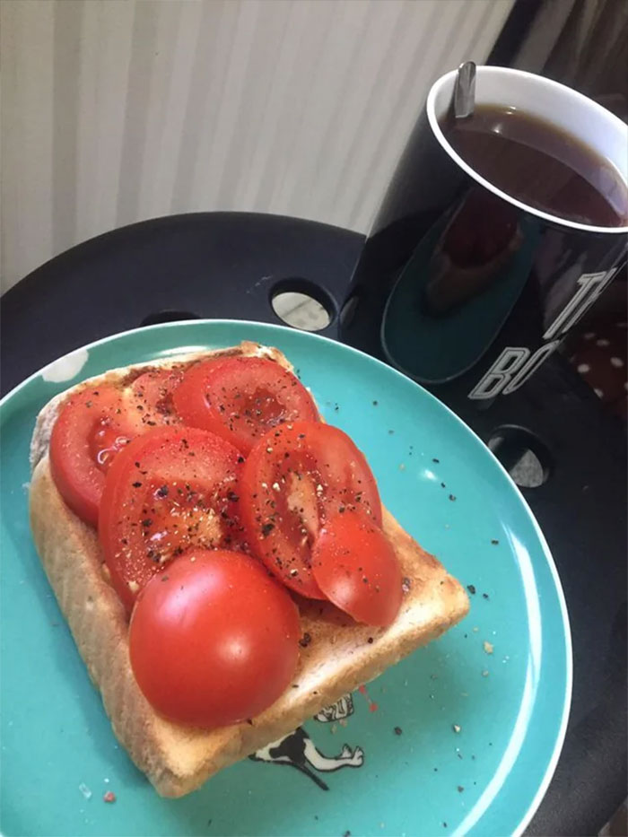 Plate of sandwich with tomatoes and peppers and mug of tea