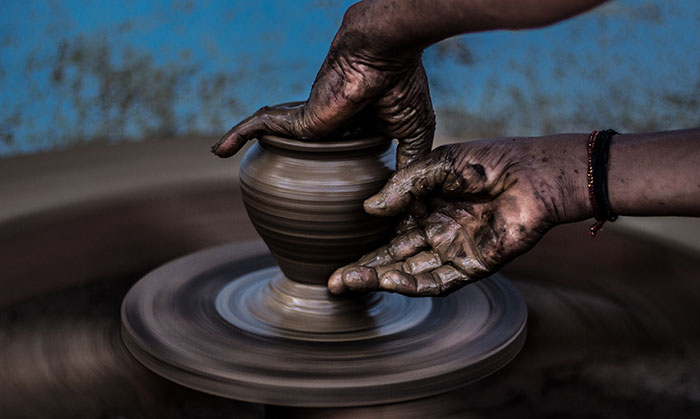 Person making pot at pottery class
