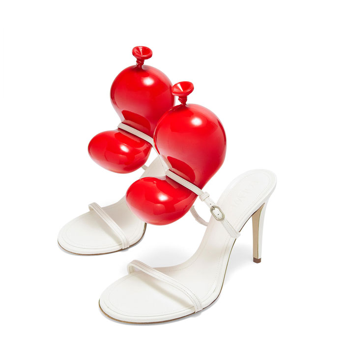 Weird shoes with white straps and red balloon-like heels.