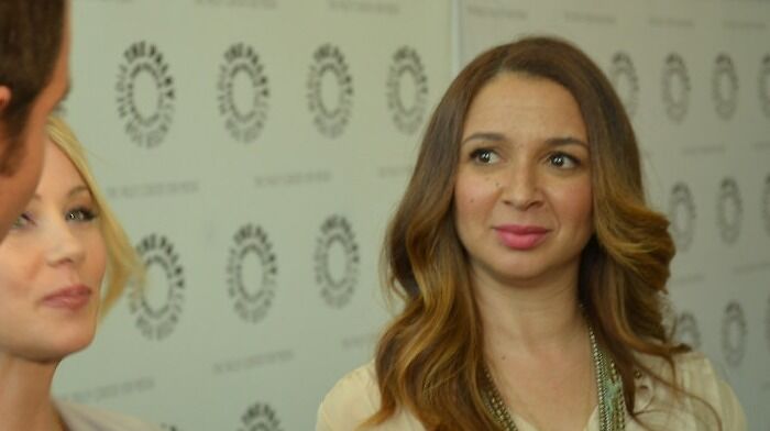 Maya Rudolph on the red carpet, one of the celebrities who never married yet found love, smiling in a light outfit.