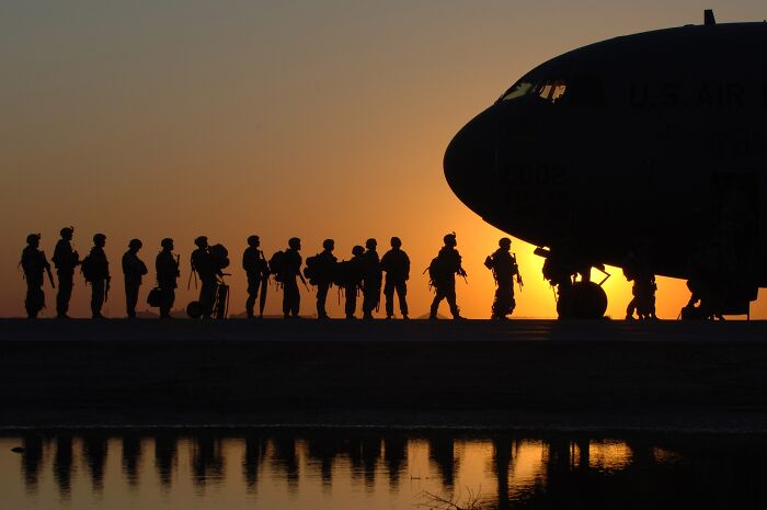 militaries standing in a queue in front of the plane