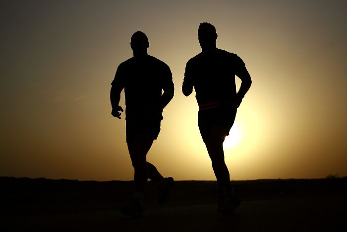 two men running on the background of the sunset