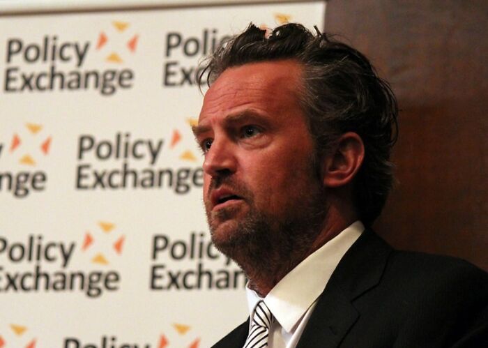 Matthew Perry wearing a tie at a Policy Exchange event, one of the celebrities who never married yet found love.
