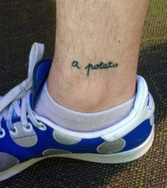 Funny tattoo of the words "a potato" on a person's ankle wearing white socks and blue polka dot sneakers.