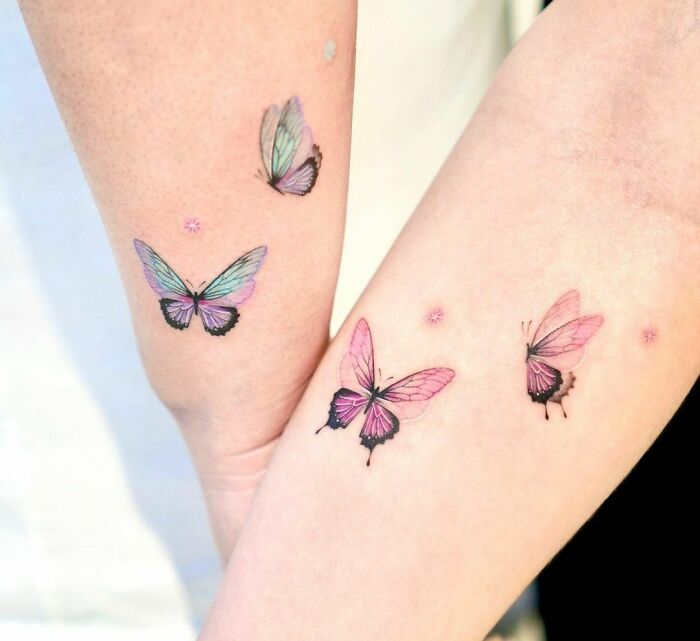 Matching butterfly best friend tattoos on arms, symbolizing a lasting friendship.