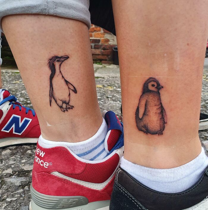 Penguin best friend tattoos on ankles, symbolizing eternal friendship, with colorful sneakers in the background.