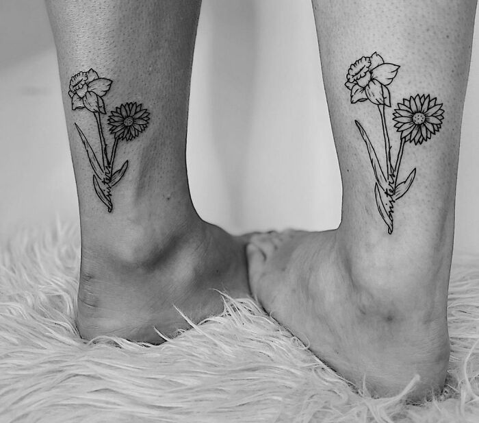 Matching flower tattoos on ankles, symbolizing best friend friendship.