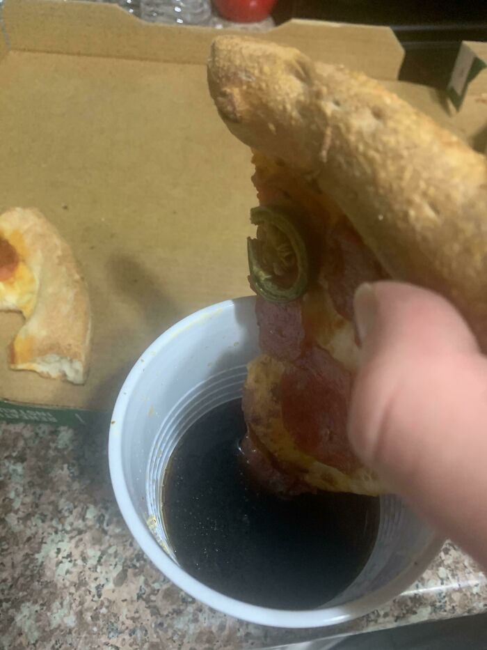 Slice of pizza dipped in soda