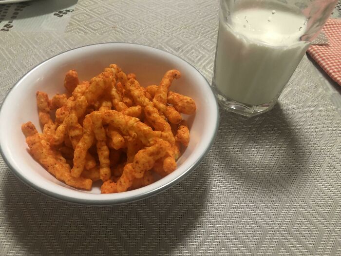Bowl of Cheetos chips and glass of milk