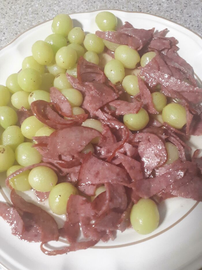 Salami and grapes served in white plate