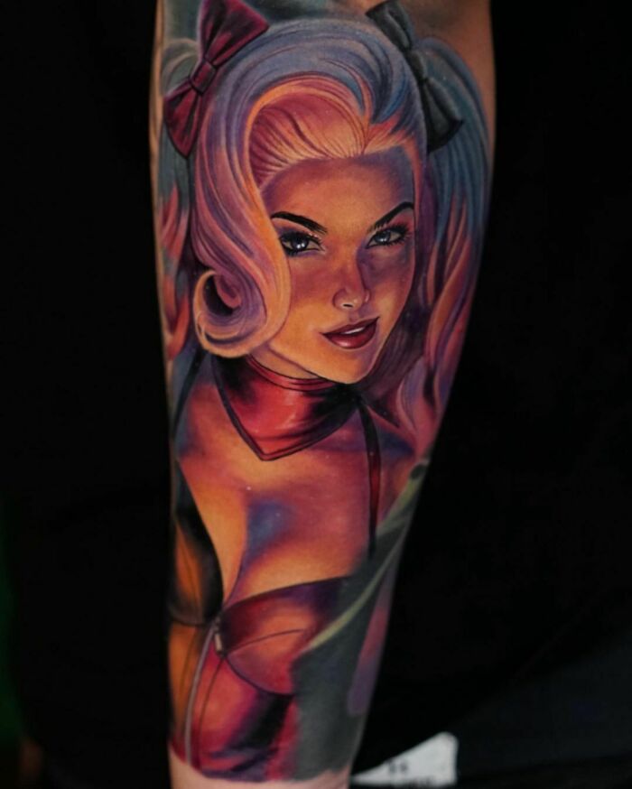 A super realistic tattoo of a woman with blonde hair, wearing a red outfit, showcasing detailed artistry.