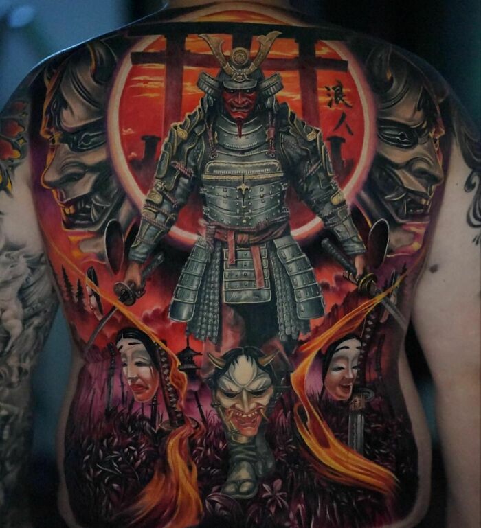Super realistic back tattoo depicting a samurai in armor with vibrant red and orange accents.