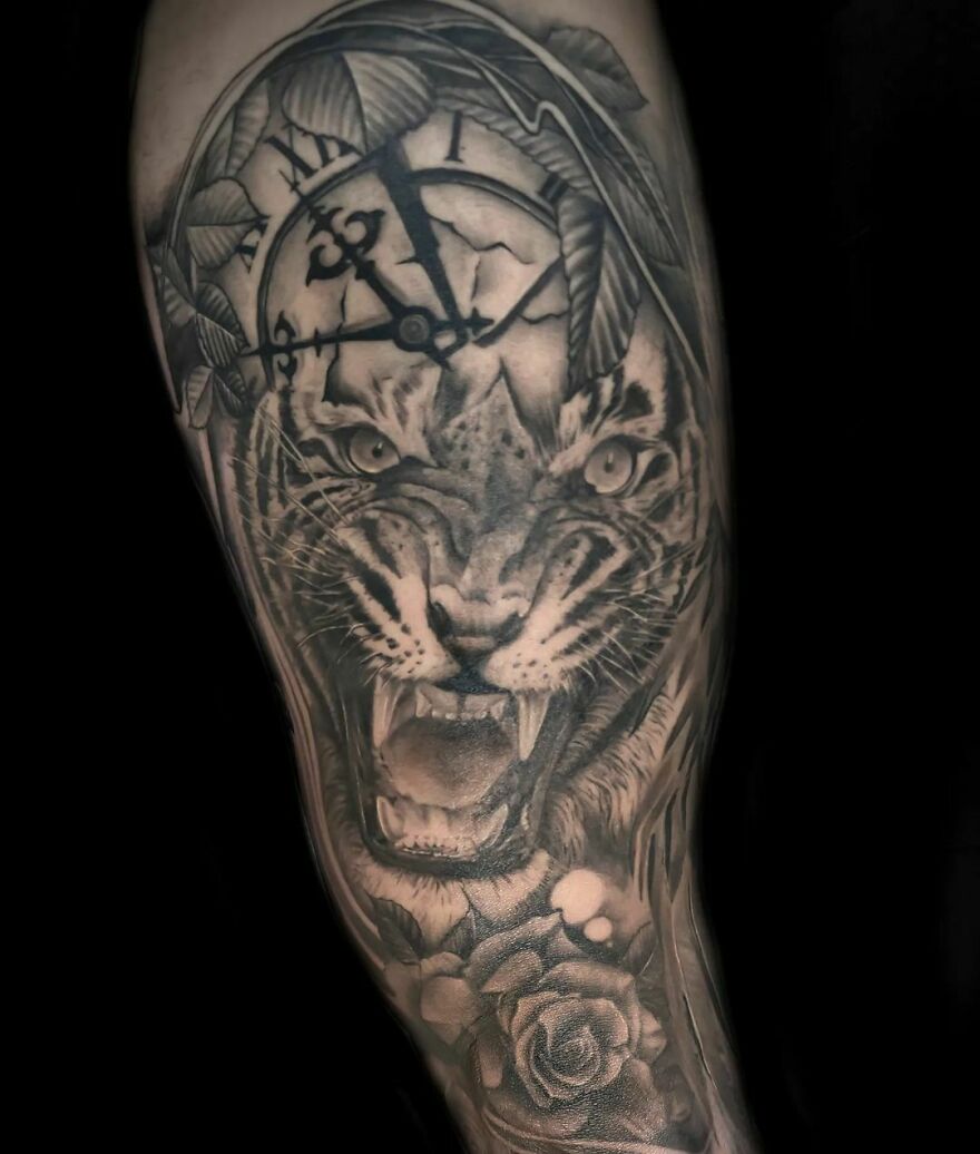 A realistic tattoo featuring a tiger, clock, and rose with intricate detailing.