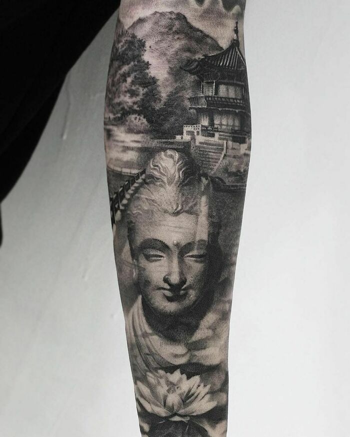 Realistic tattoo depicting a serene Buddha face and traditional Asian architecture on a forearm.
