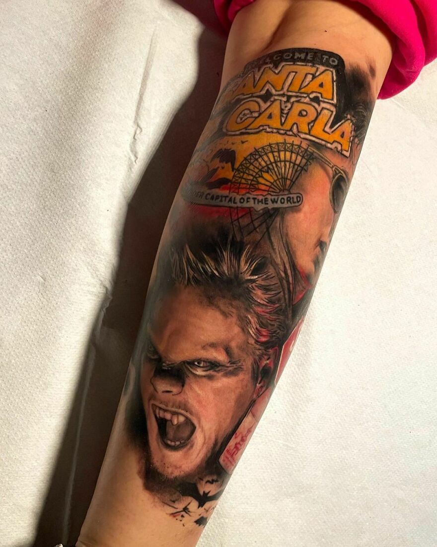 Realistic arm tattoo with Santa Carla theme, featuring intricate vampire design and detailed lettering.