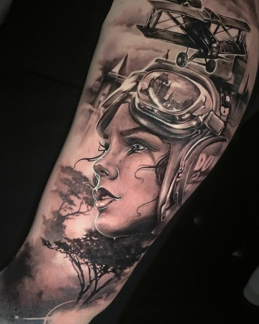 Super realistic tattoo of a woman pilot with an airplane above her head, showcasing intricate detailing.